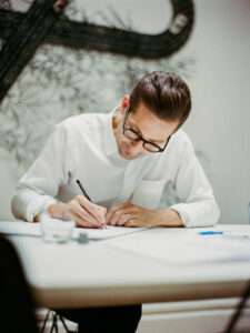 Serge Rusak sketching custom table design in minimalist atelier