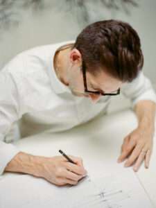 Serge Rusak sketching custom table design in minimalist atelier