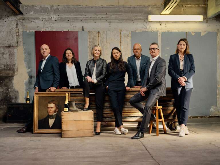 Group of Krug Champagne tasting experts posing together in a vibrant setting