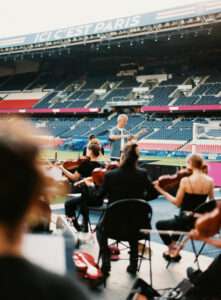 Contrast of classical musicians and fireworks at PSG stadium, conducted by Thomas Roussel