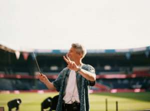 Wide shot of classical orchestra performing at PSG stadium under Thomas Roussel's direction
